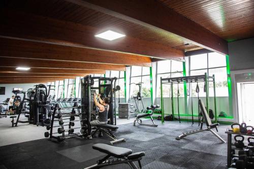 a woman exercising in a gym with tread machines at Glenville House - Adults Only - Incl FREE off-site health club with swimming pool, hot tub, sauna & steam room in Windermere