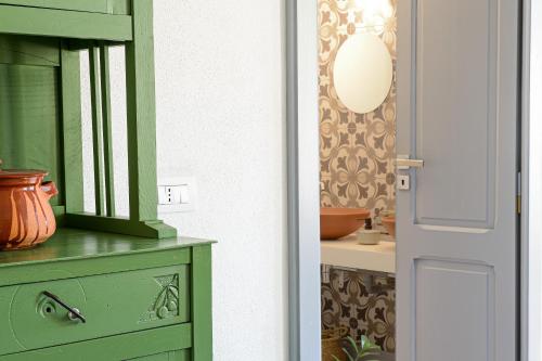 een groene kast met een spiegel op een dressoir bij Casa Mediterranea in Nurachi