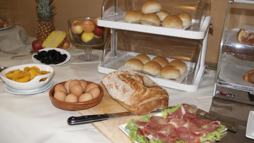 a table with bread rolls and other food on it at Hotel Astoria in Fidenza