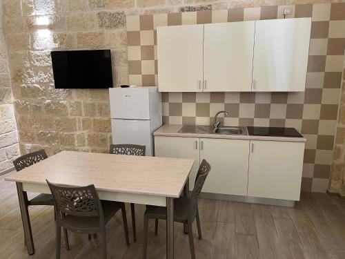 a kitchen with a table and chairs and a refrigerator at Principe Amedeo in Trani