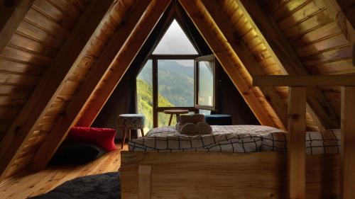 a bedroom in a log cabin with a large window at Orca Bungalows in Ardeşen