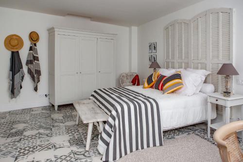 a white bedroom with a bed and a table and a desk at L’annexe in Orange