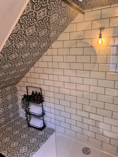 a bathroom with a white tiled wall at Park House Self-Contained Annex in Mold