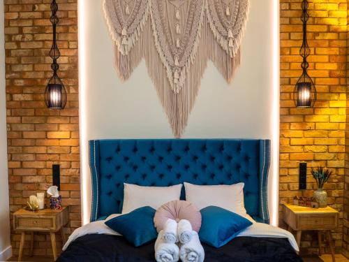 a bedroom with a blue bed with two people laying on it at Brick Castle - Apartament Ulrich in Wrocław