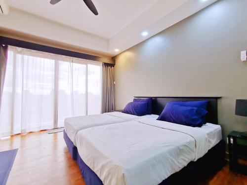 a bedroom with two beds with blue pillows and a window at 【Amazing】Pool View 2BR Suite @ Pulai Springs Resort in Skudai