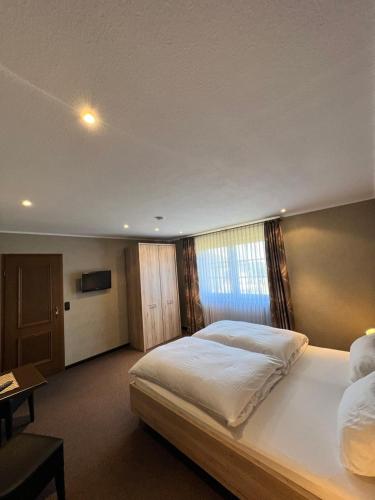 a bedroom with a large white bed with a window at Aparts4ring Nürburg in Nürburg