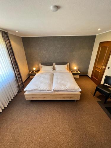 a bedroom with a large bed with white sheets and pillows at Aparts4ring Nürburg in Nürburg