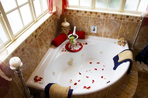 a bath tub filled with lots of hearts in a bathroom at The Angels Place Boutique Guest House in Pretoria