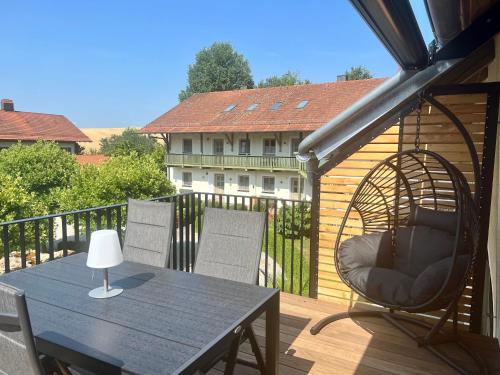 a patio with a table and chairs on a balcony at Gut Schwarz-n Hof Ferienwohnungen in Bad Griesbach