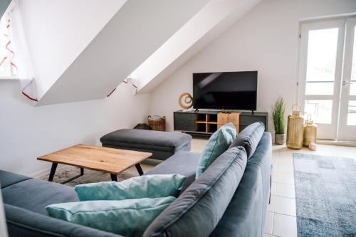 a living room with a couch and a tv at Landhaus dasThomas in Henndorf 