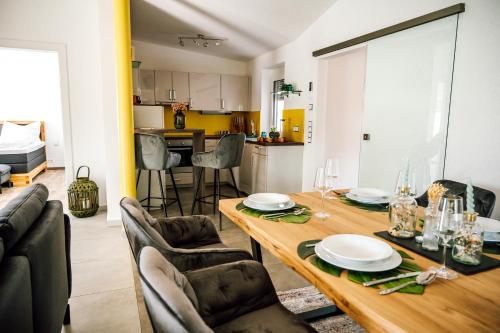 a living room with a table and chairs and a kitchen at Landhaus dasThomas in Henndorf 