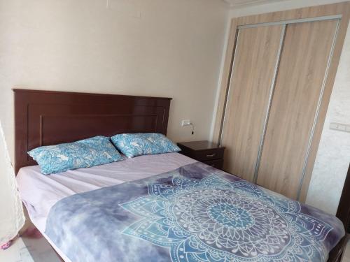 a bedroom with a large bed with a wooden headboard at Nador hay al Matar in Nador