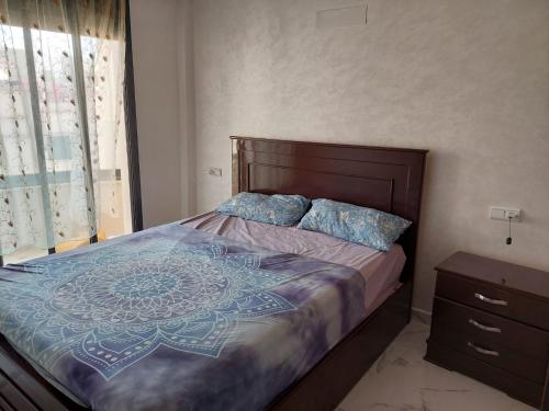 a bedroom with a large bed with a wooden headboard at Nador hay al Matar in Nador