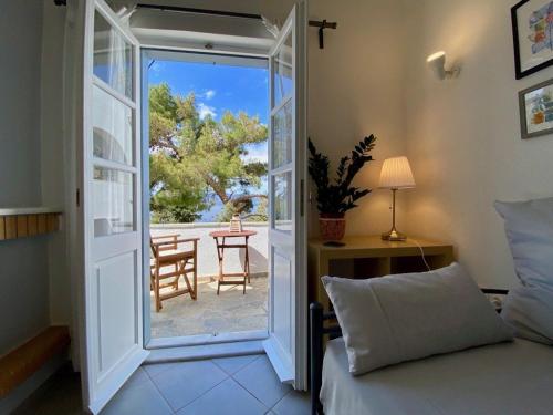 a bedroom with a door open to a patio at Pine Trees and Sea View Houses in Hydra - Daphne, Chloe, Myrto, Eleni in Hydra