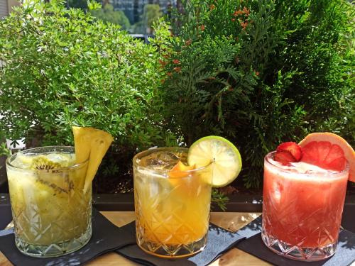 a group of three cocktails sitting on a table at Locanda degli Artisti Art Hotel in Canazei