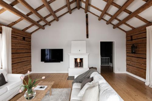 a living room with a white couch and a fireplace at Charming Villa at Askersund Golf Resort in Åmmeberg
