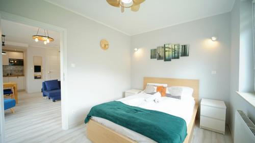 - une chambre avec un lit et une couverture verte dans l'établissement Apartamenty EverySky - Waryńskiego 1b, à Szklarska Poręba
