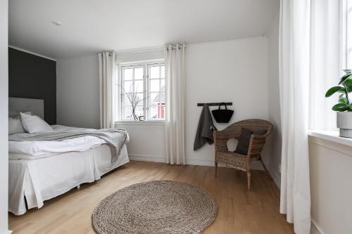 een slaapkamer met een bed, een stoel en een raam bij Charming Villa at Askersund Golf Resort in Åmmeberg