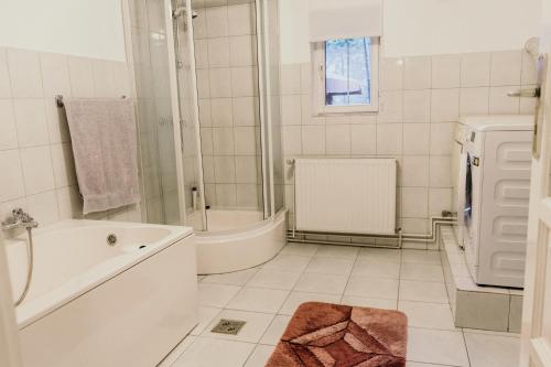 a white bathroom with a tub and a sink at La Conac 13 Ceasuri Bune in Bran