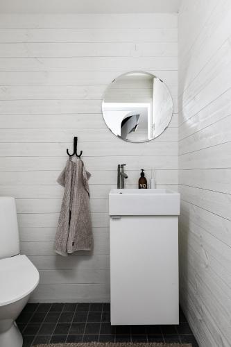 a white bathroom with a sink and a mirror at Charming Villa at Askersund Golf Resort in Åmmeberg