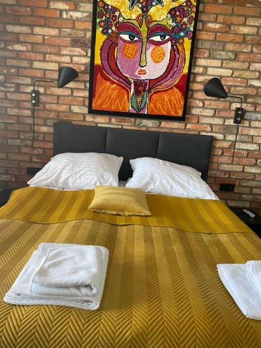 ワルシャワにあるApartament Rzekotka Zielona Dereniowa 60の大型ベッド(壁に絵画付)