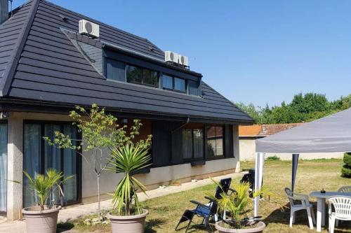 una casa con techo negro y algunas plantas en L'Escale du Monde, en Vénissieux