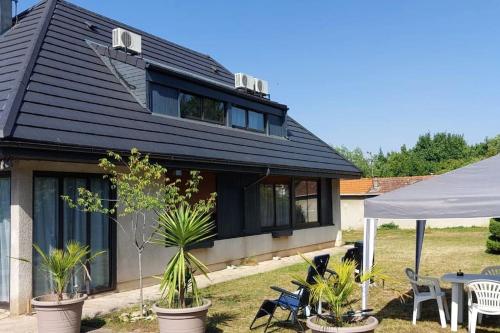 a house with a black roof and some plants at L'Escale du Monde in Vénissieux