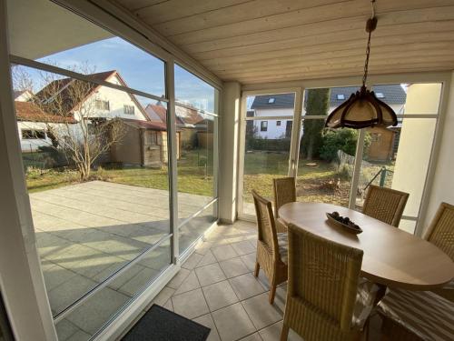 a screened in porch with a table and chairs at Ferienhaus Kutzenhausen in Kutzenhausen