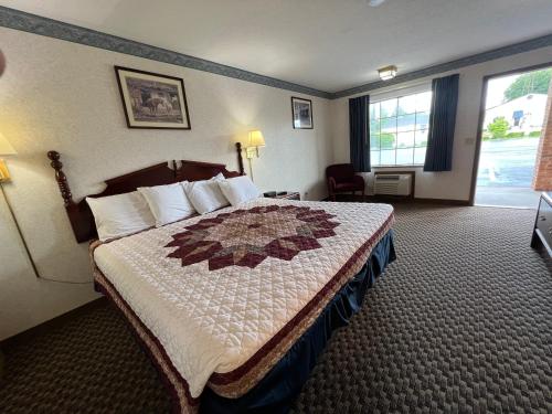 a hotel room with a bed and a window at Americas Inn Bardstown in Bardstown