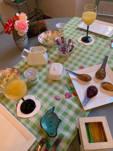 a table with a table cloth with food and drinks at LE Doux Nid La Classique in Saint-Aulaye