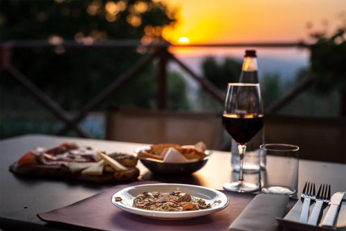 a table with a plate of food and a glass of wine at Albergo Ristorante Il Terziere in Trevi
