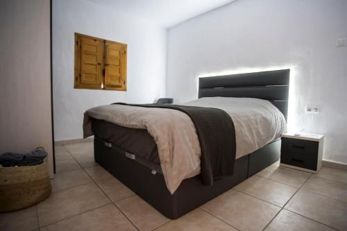 sypialnia z dużym łóżkiem z drewnianym zagłówkiem w obiekcie Casa Lumbreras w mieście Esparragalico