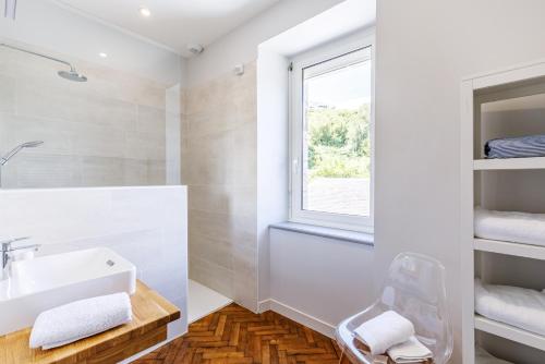une salle de bain avec un lavabo et une fenêtre dans l'établissement Villa Les Roches Mauves - vue mer, à Plouha