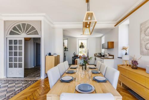 une salle à manger avec une table en bois et des chaises blanches dans l'établissement Villa Les Roches Mauves - vue mer, à Plouha