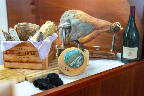 a table with a bottle of wine and a box of cheese at Albergo Ristorante Il Terziere in Trevi