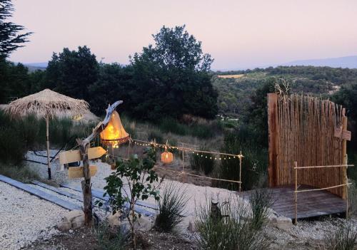 a garden with a bell and a fence with lights at chambre d'hôtes Et Puis Voilà! in Murs