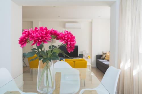 eine Vase rosafarbener Blumen auf einem Glastisch in der Unterkunft Precioso Apartamento 2 hab. en Malaga Centro in Málaga
