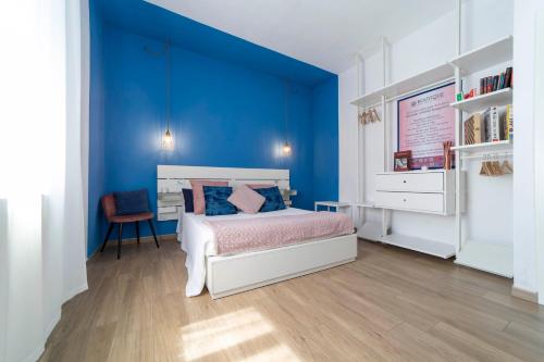 Dormitorio azul con cama y escritorio en Boutique Apartment, en Chiusi