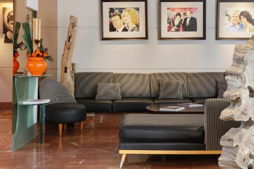 a living room with a couch and pictures on the wall at Best Western Premier Le Patio des Artistes Wellness Jacuzzi in Cannes