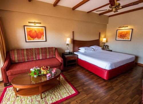 a hotel room with a bed and a couch at The Carlton Kodaikanal in Kodaikānāl