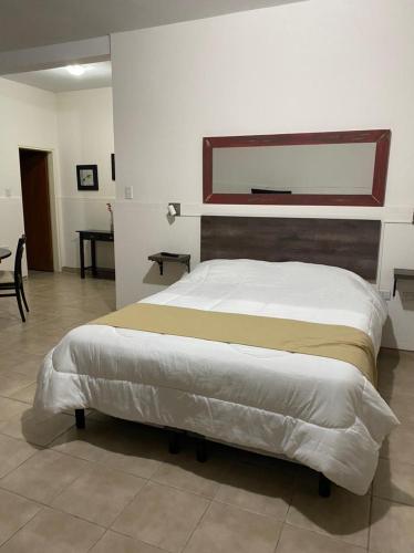 a bedroom with a large bed with a wooden headboard at Complejo Las Moras in Santa Rosa
