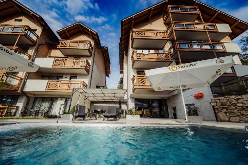 a hotel with a swimming pool in front of a building at Five Seasons Szklarska Poręba in Szklarska Poręba