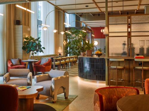 a restaurant with tables and chairs and a bar at TRIBE London Canary Wharf in London