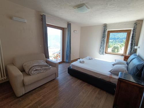 a bedroom with a bed and a couch and a window at Les Flocons Pila in Pila