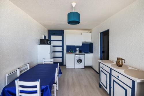 - une cuisine avec une table bleue dans une pièce dans l'établissement Le front de mer, au Barcarès