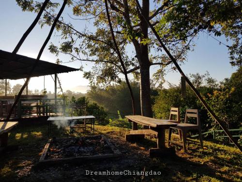 a picnic table and a fire in a field at Dreamhome Chiangdao in Chiang Dao