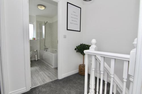 a white bathroom with a bath tub and a sink at Dashing 2Bed Haven - Near Coventry Centre, Free Parking in Coventry