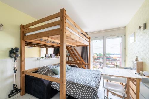 ein Schlafzimmer mit einem Etagenbett und einem Schreibtisch in der Unterkunft L'Effet Mer in La Richardais