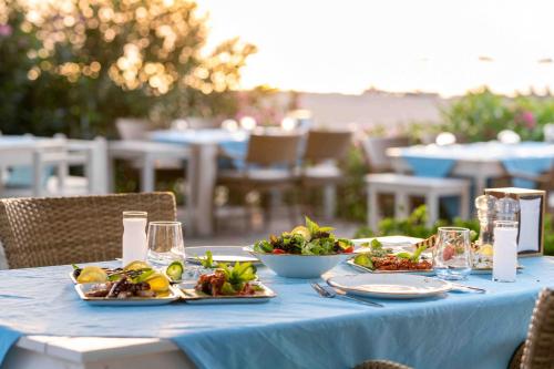 a blue table with plates of food on it at Etenna Beach Bungalows in Cıralı