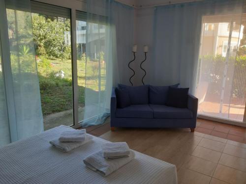 a living room with a bed and a blue couch at Palio Villa in Paleo Tsifliki